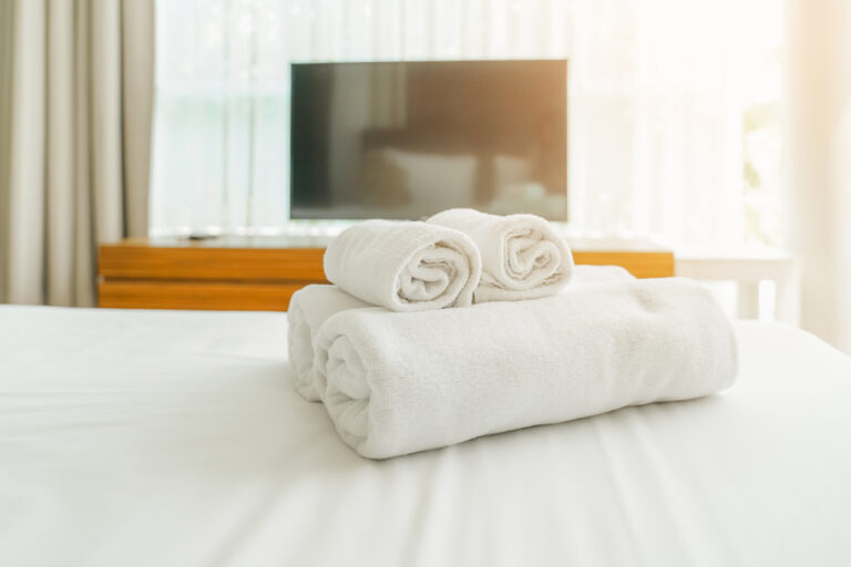 white fluffy towels on bed for hotel customer