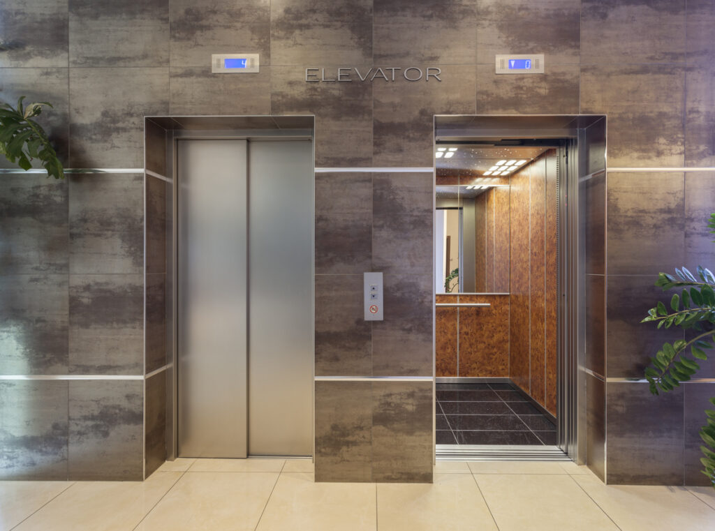 Two elevators shot from outside, one open and other closed. Elevator facility maintenance